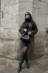 a lady in a grey wool long coat and a black long sweater